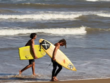 surfistas caminando por la playa el emir