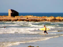 surfista entrando al oceano en la playa el emir