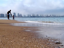 padre con su hijo en la orilla de la playa mansa