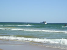 mar de la playa tio tom con motos de agua y una lancha
